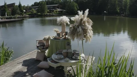 Close drone rotation by lakeside table setup Vidéo 329540192