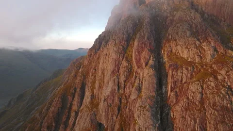 Close up drone of Scottish mountain cliffs (Buchaille Etive Mor) at sunrise Stock Footage 254708577