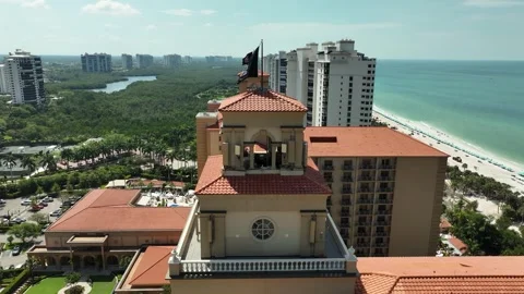 Close-up drone shot of the top of Ritz-Carlton Naples overlooking the beach. Video stock 334303194