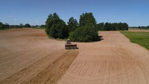 Close up drone shot of a tractor seeding a field in spring Stock Footage 90946754