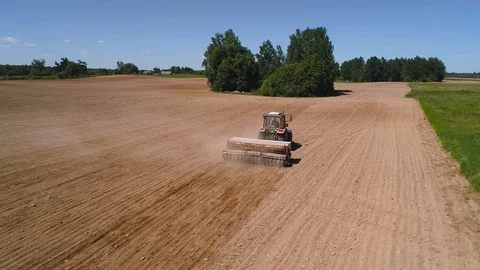 Close up drone shot of a tractor seeding a field Stock Footage 90947002