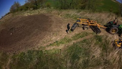 Close up drone view of a farmer inspecting tillage machinery Foto stock