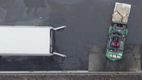 Close-up drone view of forklift in parking lot loading white sprinter van Stock Footage 346249166