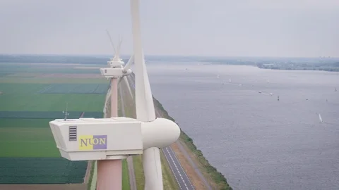 A close droneshot of a Windmill pulling down towards the road Stock Footage 100824423