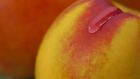 Close-up of a drop of water flowing down the surface of a ripe juicy peach Stock Footage 137629988