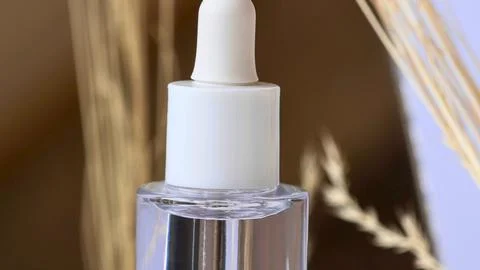 Close up of a dropper bottle with clear liquid and natural background Foto stock