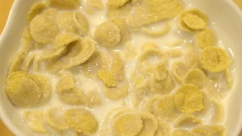 Close up dropping corn flakes to a bowl Stock Footage 109535986