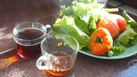 Close-up of drops of tea falling into glass mug. Slow motion Stock Footage 80274359