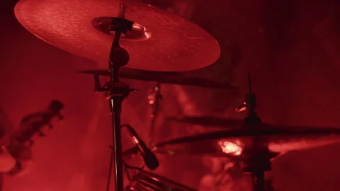 Close up of drum set with cymbal under red light on smoky stage at live rock Видео 338418436