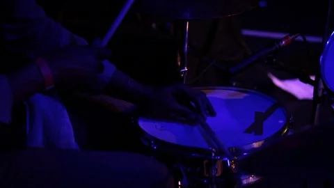 Close up of drummer playing drum kit on stage under blue stage lights Stock-Footage 98743808