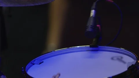 Close-up of drums with microphone on stage with people waking by Stock Footage 114644557