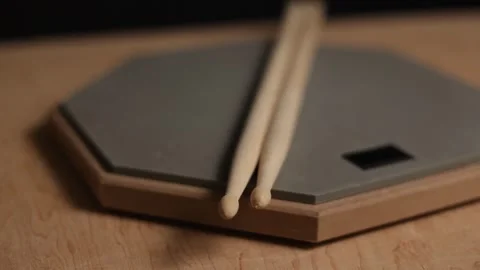 Close-up of drumsticks resting on a practice pad with wooden surface Stockbeeldmateriaal 341737436