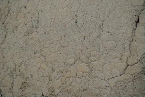 Close up of a dry cracked mud wall texture in a rural agricultural setting. Stock Photos