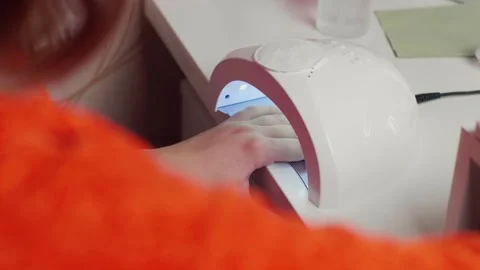 Close-up of drying gel nails with LED lamp. Technology of polymerization of Stock Footage 295507445