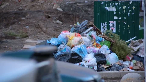 Close-up dump of garbage bags with waste lying on ground next to trash cans Video stock 101540328