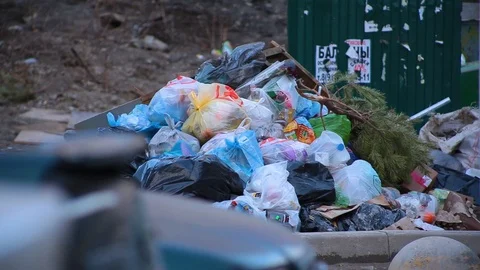Close-up dump of garbage bags with waste lying on ground next to trash cans Stock Footage 101540362
