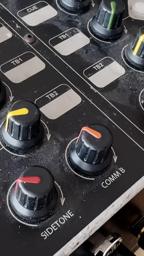 Close-up of a dusty audio intercom control panel with colored COMM knobs, cue Stock-Footage 337228816