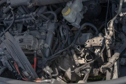 Close-up of a dusty car engine bay with hoses, wiring, and fluid reservoir .. Stock Photos