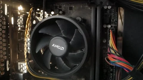 Close-up of a dusty computer system unit with an AMD fan. Visible cables and Stock Footage 336472304