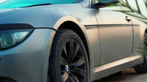 Close up dusty grey BMW car parked outdoors Stock Footage 337110956
