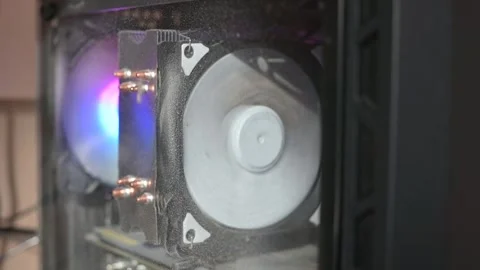 Close up of dusty RGB computer cooling fan in assembled PC running slowly due to Video stock 337101495