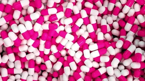Close up dynamic view of white and pink medicine pills on dark background Stock Footage 327572529