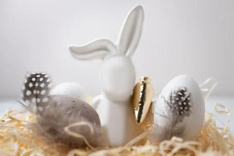 Close-up of Easter bunny and eggs in straw nest. Copy space Stock Photos