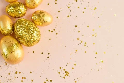 Close-up of Easter eggs with gold sequins on a beige background. Stock Photos