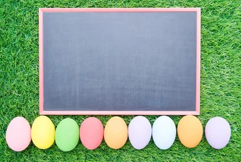Close up Easter eggs on grass and blackboard mockup Stock Photos