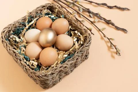 Close up of easter eggs natural and gold in basket with gold and green paper Stockfoto's