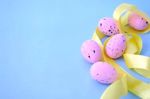 Close up easter right side border, pink eggs with yellow ribbon on pastel blue Stock Photos