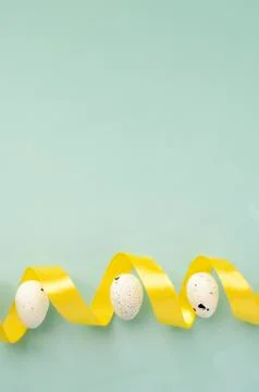 Close up easter right side border, pink eggs with yellow ribbon on pastel blu Foto stock
