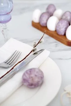 Close-up of Easter table setting with purple decorations, willow branches and Stock Photos