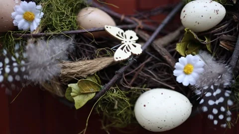 Close-up of an Easter wreath featuring speckled eggs, faux flowers, feathers, an Stock Footage 306007978