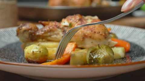 Close-up of eating with fork and knife freshly roasted chicken with vegetables. Stock Footage 145119082