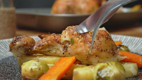 Close-up of eating with fork and knife freshly roasted chicken with vegetables. Stock Footage 145119180