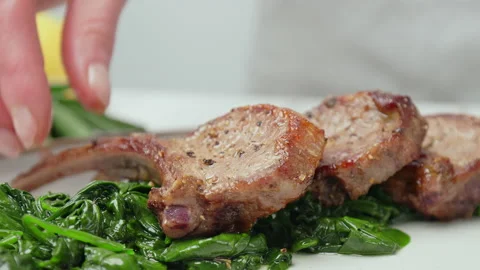 Close-up eating nicely cooked lamb ribs cutlets from a serving plate in 4K. Stock Footage 146000952