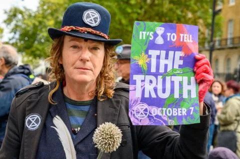 Close up of eccentric Extinction Rebellion Protester holding a protest sign a Stock Photos