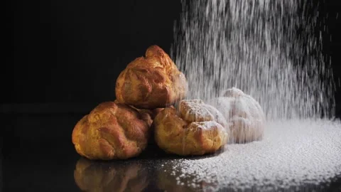 Close-up of an eclair on a black plate sprinkled with powdered sugar. Decorating Stock Footage 152107060