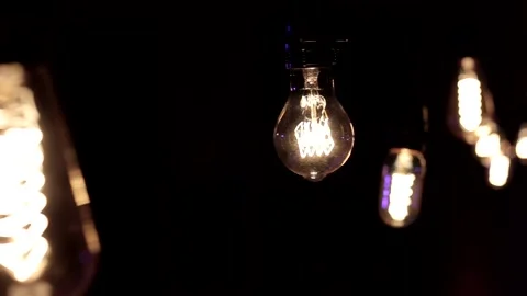 Close-up of the Edison lamp with warm light sways lightly on a black backgrou Stock Footage 146816219