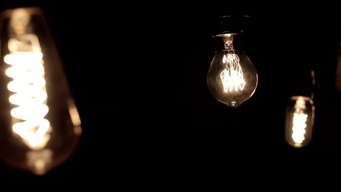 Close-up of the Edison lamp with warm light sways lightly on a black backgrou Stock Footage 146816238
