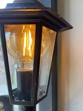 Close up of edison style lightbulb in a lantern Stock Photos