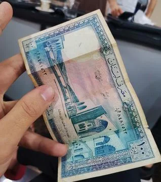 A close-up editorial view of a hand holding a vintage one Lebanese lira banknote Stock Photos