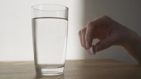 Close up of effervescent tablet dissolves into glass of water. Aspirin Video stock 150297536
