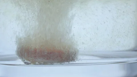 Close up of effervescent vitamin tablet dissolving in glass of water. 4K Stock Footage 126005235