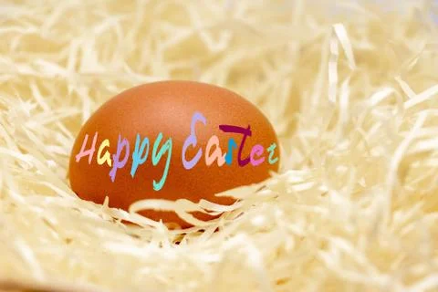 Close up of egg with easter text in nest Stock Photos
