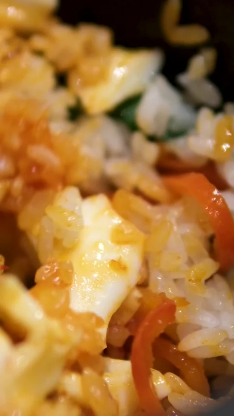 Close-up of egg fried rice with carrots and green peas, using spatula to stir Stock Footage 306931759