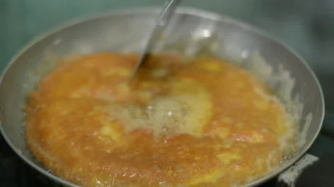 Close Up of Egg Omelet Frying and Sizzling in Hot Bubbling Oil Stock Footage 344880469