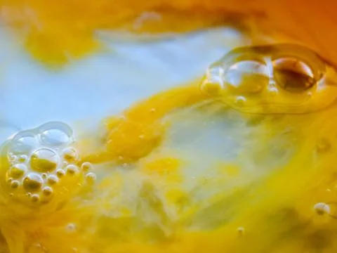 Close up egg yolk macro shot food yellow and white texture liquid bubbles Stock Photos