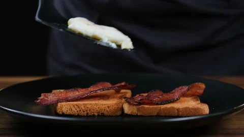 Close-up of eggs benedict being placed on bacon toast Stock Footage 187667879